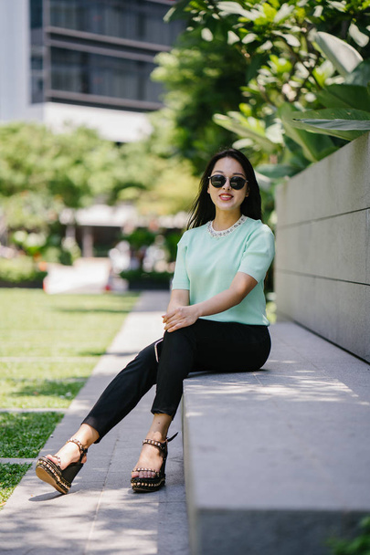 Portrait of a young, sexy and glamorous Asian woman during the day. She is wearing a mint green sweater - Foto, afbeelding