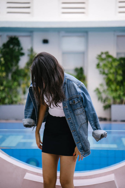 Portrait of a beautiful, young and attractive Indian Asian woman in a white top, blue skirt and denim jacket. - Foto, afbeelding