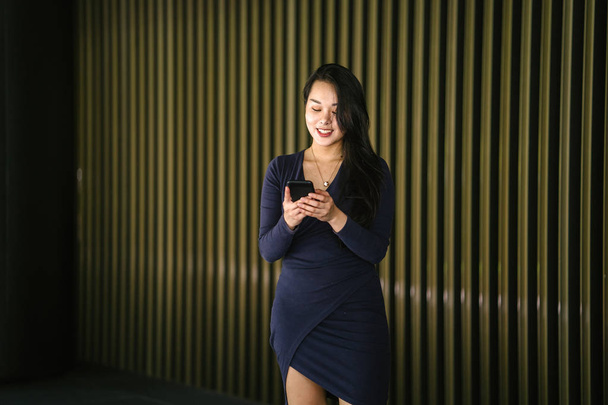 Retrato de una joven y hermosa mujer china asiática sosteniendo teléfono inteligente
 - Foto, Imagen