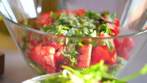 Close up shot of young woman spicing salad from fresh vegetables - Filmati, video