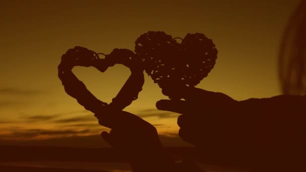 La pareja amorosa sostiene los corazones al atardecer. Luna de miel romántica. Día de San Valentín. Primer plano
 - Imágenes, Vídeo