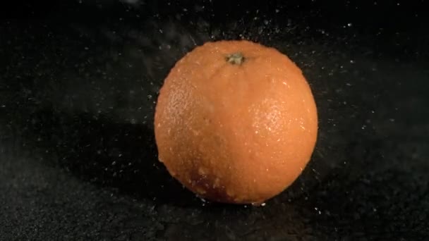 Water raining on orange in super slow motion - Filmati, video