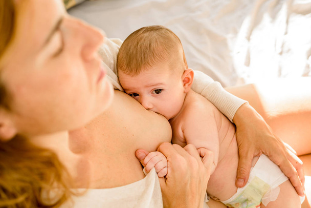 Το μωρό θηλάζει για το μητρικό γάλα, εναλλακτική έννοια της μητρότητας - Φωτογραφία, εικόνα