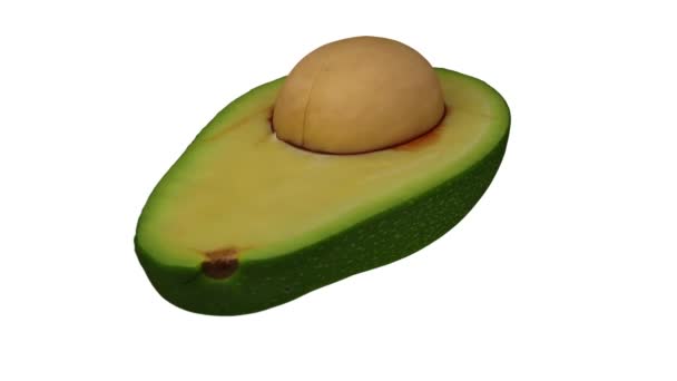 Realistische weergave van een draaiende groene Florida avocado (doormidden gesneden met pit) op witte achtergrond. De video is naadloos looping, en het object is 3d gescand van een echte avocado. - Video