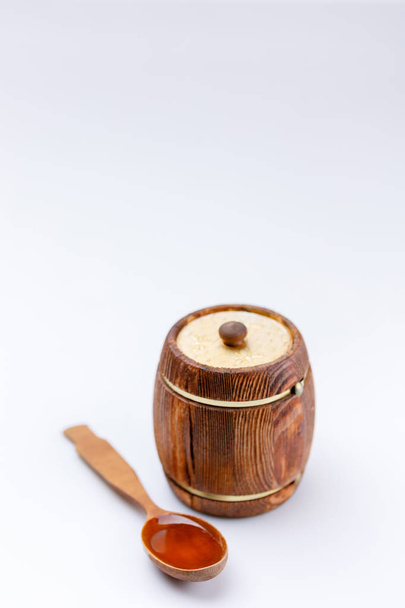 Isolated barrel and spoon with honey on a white background. Close-up. - Φωτογραφία, εικόνα