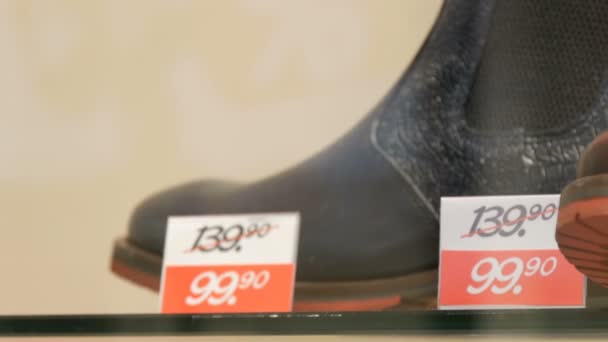Botas de lujo de cuero costosas en la tienda de escaparate de zapatos junto a la etiqueta de precio de descuento de cerca ver
 - Metraje, vídeo