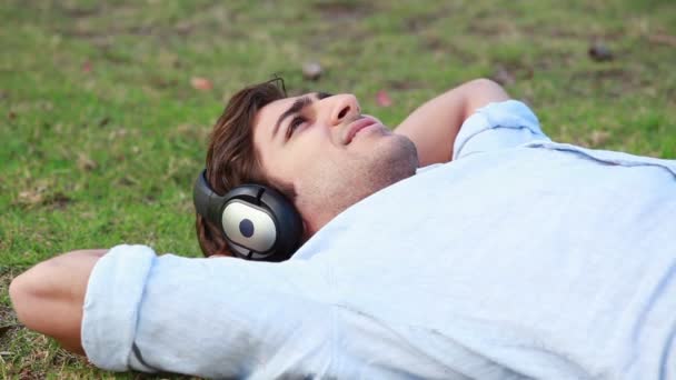 A man lies down while listening to music on his headphones - Séquence, vidéo