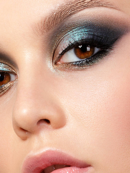 Close up beauty portrait of young woman with beautiful fashion makeup. Modern fashion makeup. Colorful smokey eyes. Studio shot. Extreme closeup, partial face view - Φωτογραφία, εικόνα