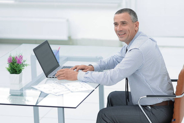 smiling businessman sitting at Desk and looking at camera - 写真・画像
