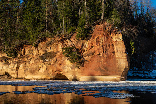 sandstone cliffs on shore of river Gauja in winter in Latvia - Fotografie, Obrázek