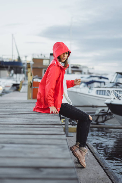 schöne junge Frau in rotem Mantel im Yachthafen. Stockholm, Schweden - Foto, Bild