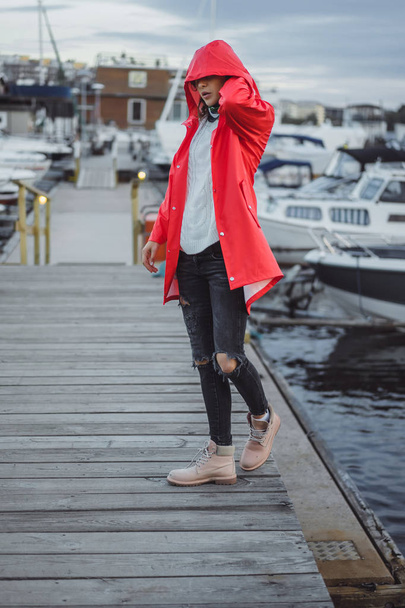 Beautiful young woman in a red cloak in the yacht port. Stockholm, Sweden - Foto, immagini