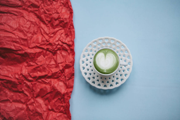 Una taza con un sabroso y aromático café matcha latte de la mañana sobre un fondo festivo
. - Foto, Imagen
