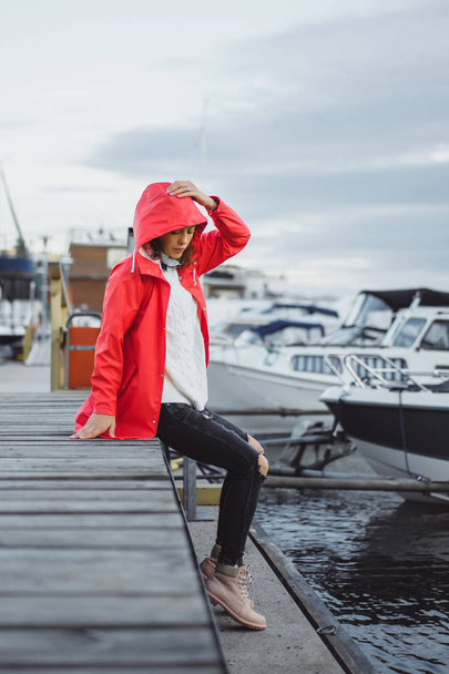 Beautiful young woman in a red cloak in the yacht port. Stockholm, Sweden - Фото, зображення