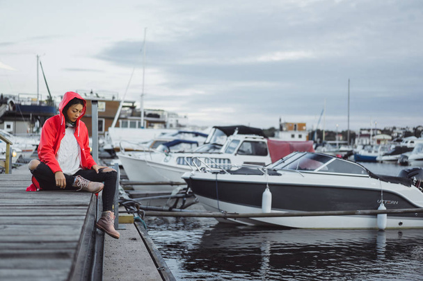 Beautiful young woman in a red cloak in the yacht port. Stockholm, Sweden - Photo, image