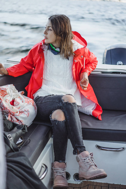 beautiful young woman in a red raincoat rides a private yacht. Stockholm, Sweden - Fotografie, Obrázek