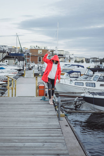schöne junge Frau in rotem Mantel im Yachthafen. Stockholm, Schweden - Foto, Bild