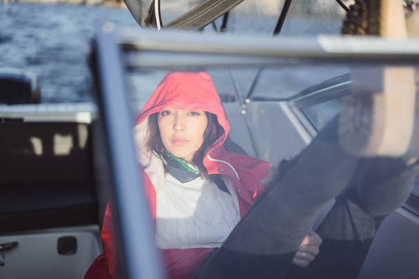 beautiful young woman in a red raincoat rides a private yacht. Stockholm, Sweden - Φωτογραφία, εικόνα