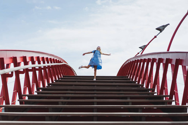 beautiful girl in a blue dress posing on the bridge - Valokuva, kuva
