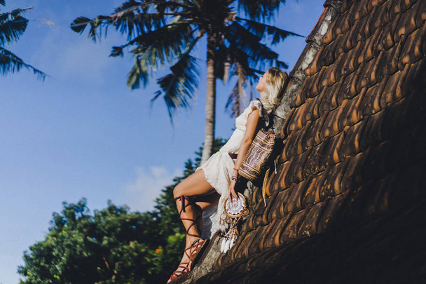 hippie girl with long blond hair in a dress on the roof. - 写真・画像