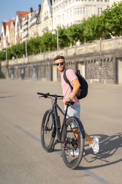 young man riding bicycle on the street - Fotó, kép