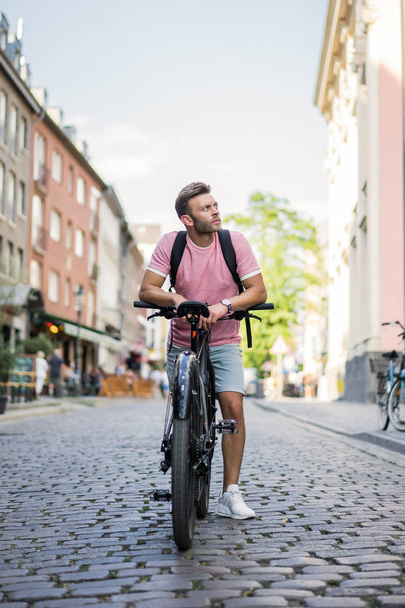 young man riding bicycle on the street - Foto, afbeelding