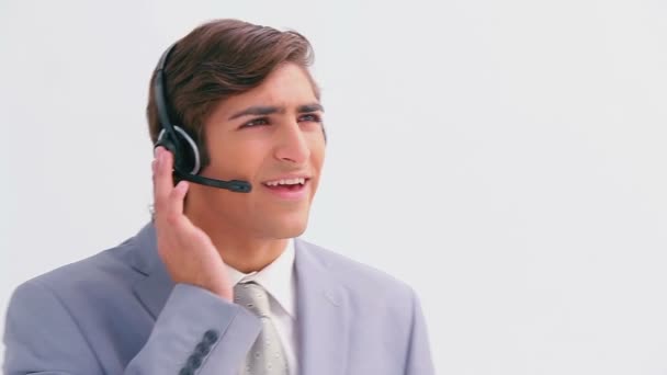 Handsome businessman talking on a headset - Кадри, відео