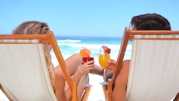 Couple on deck chairs drinking cocktails - Footage, Video