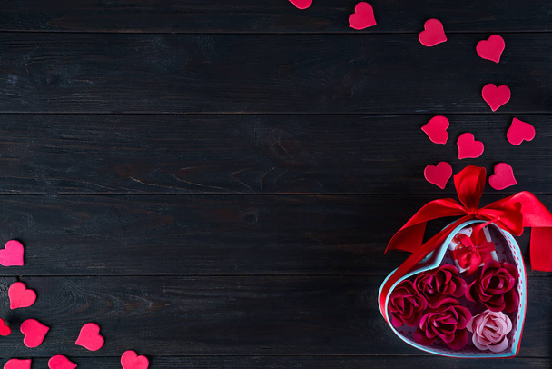 Fond de Saint-Valentin avec des cœurs rouges en forme et bouquet rose en boîte cadeau sur fond bois foncé, espace de copie plat laïc
 - Photo, image