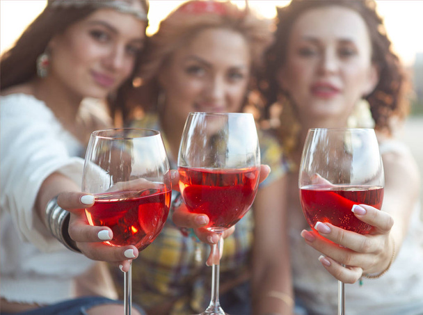 Felices amigas con copa de vino rosa en el picnic de verano en la playa
  - Foto, Imagen