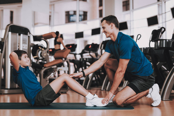 Young Father and Son Doing Exercises in Sport Club. Healthy Lifestyle Concept. Sport and Training Concepts. Modern Sport Club. Sport Equipment. Family Sport. Running Tracks. Parent with Child. - Foto, Imagem