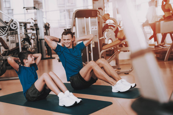 Young Father and Son Doing Exercises in Sport Club. Healthy Lifestyle Concept. Sport and Training Concepts. Modern Sport Club. Sport Equipment. Family Sport. Running Tracks. Parent with Child. - Foto, Bild