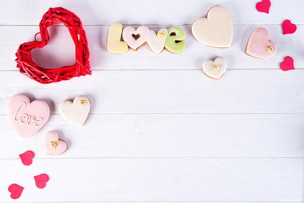 Γλυκά την ημέρα του Αγίου Βαλεντίνου. Μπισκότα σε σχήμα καρδιάς και με γράμματα αγάπης σε σκούρο φόντο ξύλινη κάτοψη αντίγραφο χώρου - Φωτογραφία, εικόνα