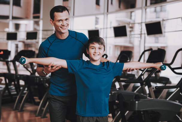 Young Father and Son Doing Exercises in Sport Club. Healthy Lifestyle Concept. Sport and Training Concepts. Modern Sport Club. Sport Equipment. Family Sport. Running Tracks. Parent with Child. - Foto, immagini