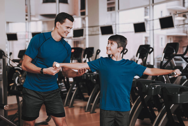 Young Father and Son Doing Exercises in Sport Club. Healthy Lifestyle Concept. Sport and Training Concepts. Modern Sport Club. Sport Equipment. Family Sport. Running Tracks. Parent with Child. - Foto, Imagen