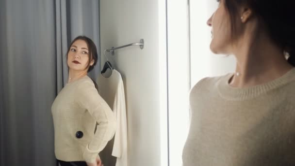 Gyönyörű nő intézkedések a ruhát egy próbafülke - Felvétel, videó