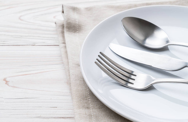 empty plate spoon fork and knife on table - Φωτογραφία, εικόνα
