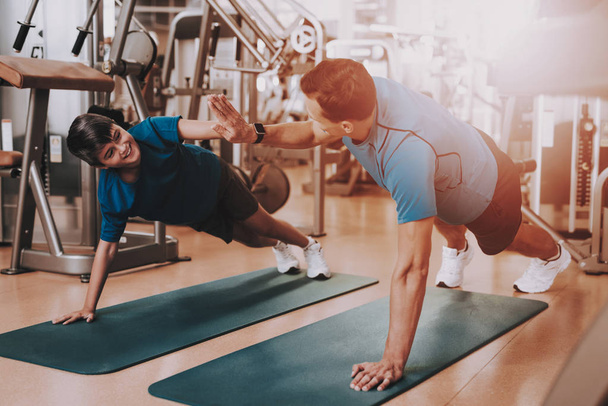 Young Father and Son Doing Exercises in Sport Club. Healthy Lifestyle Concept. Sport and Training Concepts. Modern Sport Club. Sport Equipment. Family Sport. Running Tracks. Parent with Child. - Valokuva, kuva