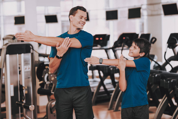 Young Father and Son Preparing for Training in Gym. Healthy Lifestyle Concept. Sport and Training Concepts. Modern Sport Club. Sport Equipment. Family Sport. Running Tracks. Parent with Child. - Φωτογραφία, εικόνα