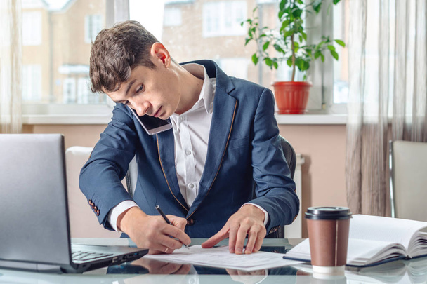 Man businessman sitting at the table signing documents in the office. Concept of registration of transactions and work with securities - Photo, Image