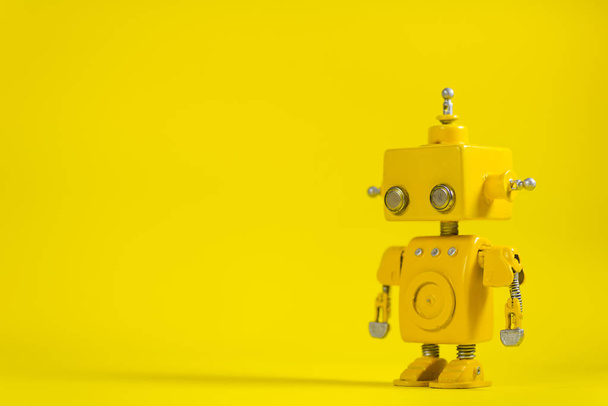 Cute, yellow, handmade robot on a yellow background. - Zdjęcie, obraz