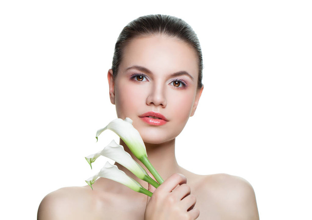 Krásná žena s zdravou pokožkou ukazující tři bílá kala květ izolovaných na bílém pozadí. Aromaterapie, ošetření obličeje, péče o pleť a wellness koncept - Fotografie, Obrázek