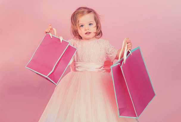 happy childhood of little girl. Kid shopping. shopping bags. Christmas gift. Thanks for your purchase. big sale in shopping mall. Happy birthday. New year party. small girl child with present package - Fotoğraf, Görsel