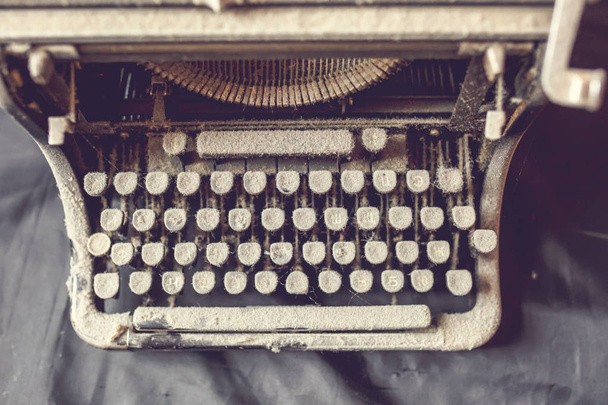 old vintage dust-covered typewriter with sheet of white paper - Foto, afbeelding