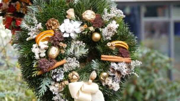 Stylové zelené vánoční věnec holly, větve jedle, anýz, sušené pomeranče a další jsou prodávány na vánoční trh - Záběry, video