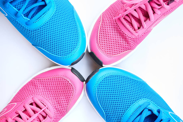 Pair of blue running sneakers for men and pair of pink one for women on white background. Concept love run. Run together. Family run. Top view. - Photo, Image