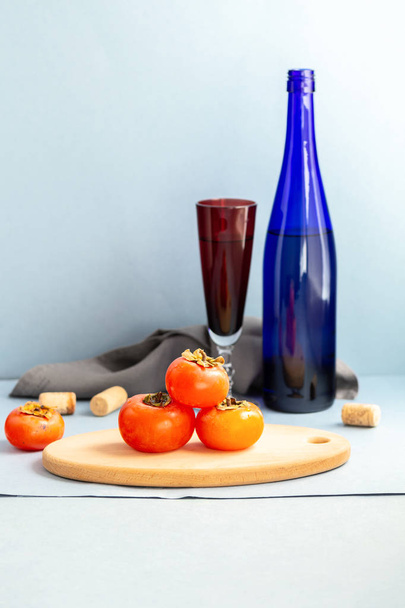 Juicy kypsä persimmon ja viini eristetty valkoisella pohjalla
 - Valokuva, kuva