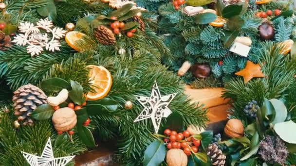 Stylish green Christmas wreath of holly, fir branches, anise, dried orange and others are sold at Christmas market - Footage, Video