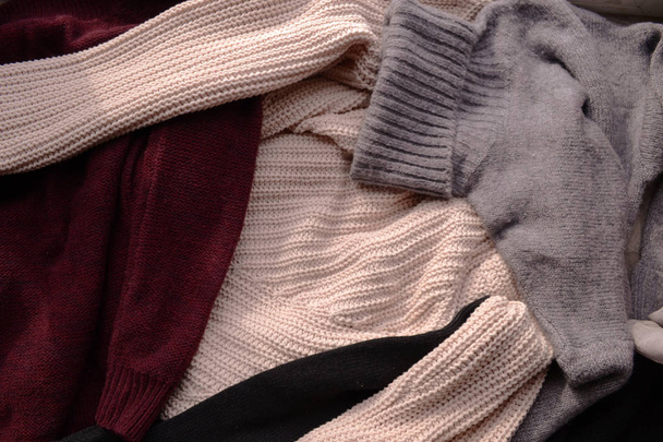 Background with warm sweaters. Pile of clothes warm background. Autumn winter concept.  - Foto, afbeelding