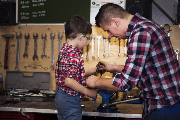 father took his little son to work with metal. Concept of relationship, child at work turner - Foto, Imagen